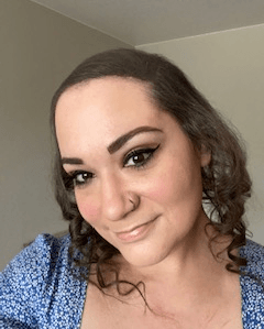 Marie Amina Aryan, NP-C, smiling, in a blue floral top
